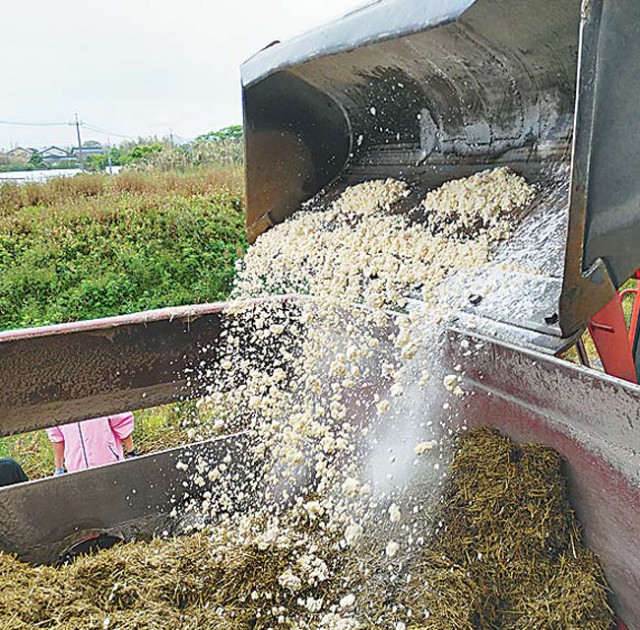 飼料化したおからを混合飼料に加える作業(鳥取県琴浦町で=大山乳業農協提供)