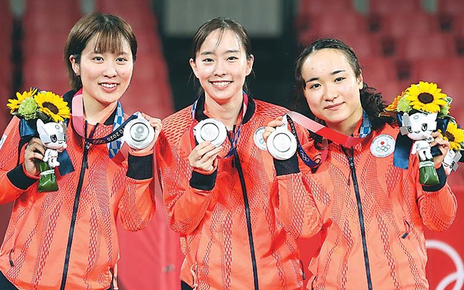 東京五輪・卓球女子団体で銀メダルを獲得し笑顔を見せる石川選手（中）ら（21年8月、東京体育館で）