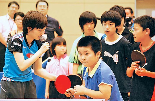 東日本大震災被災地の子どもたちを元気づけようと、宮城県石巻市で開いた卓球教室で実技を指導する石川選手（13年7月、同市で）