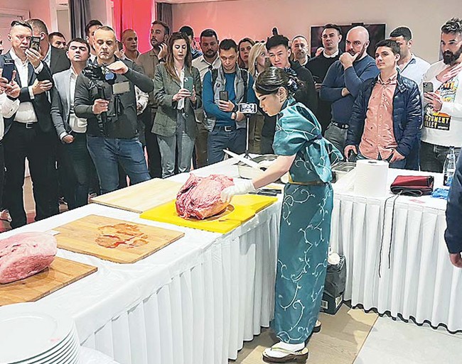 モンテネグロで4月に開かれた和牛販促イベントで現地の来場客が見守る中、和牛肉のカットを実演する渡邊さん(本人提供)