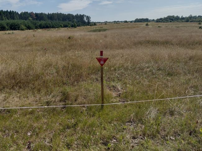 イアコベンコさんの農地に建てられた「地雷注意」の警告板（ウクライナ・チェルニヒウ市近郊で）