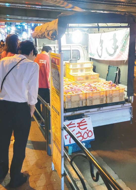 東京都内で記者が発見した桃を売る軽トラ（画像の一部を加工しています）