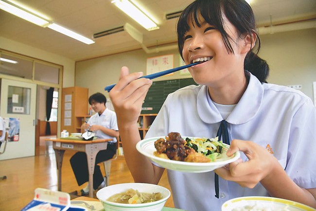お助け揚げをおいしそうに食べる女子生徒（長崎県対馬市で）