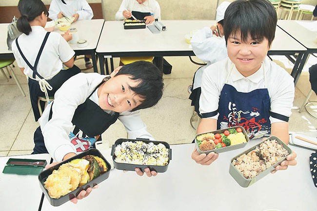 手作りの弁当を手に笑顔を見せる６年生（香川県綾川町で）