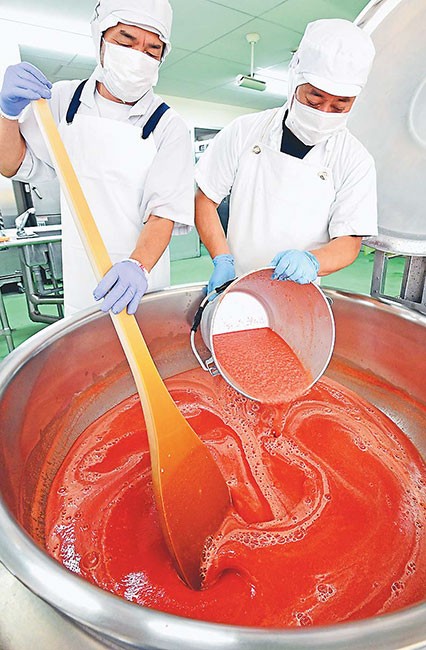 特産のトマトを長期保存できるピューレに加工する調理員（東京都日野市で）