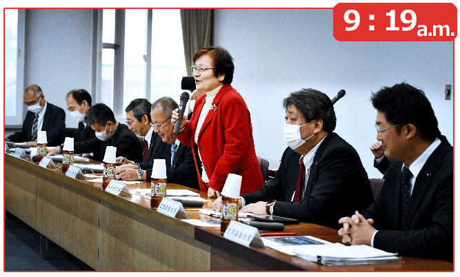 理事会冒頭であいさつ。ダークスーツの役員の中で赤いスーツが際立つ谷井さん（中）（富山市で）