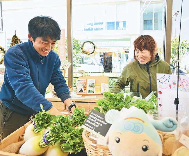 「野崎書林」のマルシェで野菜を並べる野崎さん（左）（東京都東久留米市で）
