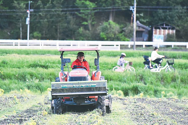 ブロッコリーの収穫を終えた畑を水田に戻すため、トラクターに乗って耕起する藤本さん（香川県東かがわ市で）