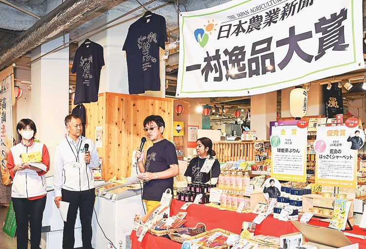 来店客に一村逸品の魅力を説明するやくみつる委員長(右から2人目)(東京・秋葉原で)