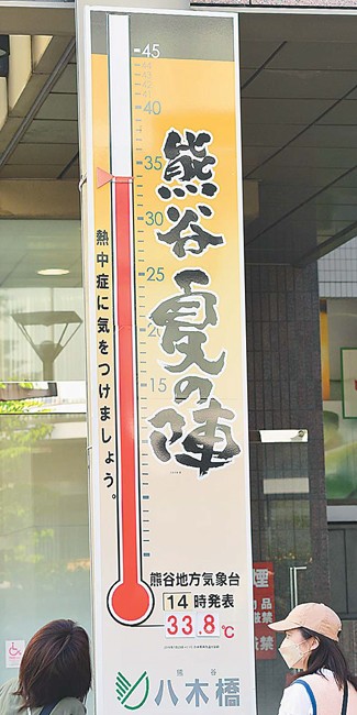 国内の観測史上最高気温記録を持つ埼玉県熊谷市の百貨店に設けられた温度計。17日午後2時時点で熊谷地方気象台が発表した33．8度を指し、足を止める人が目立った（17日、同市で）